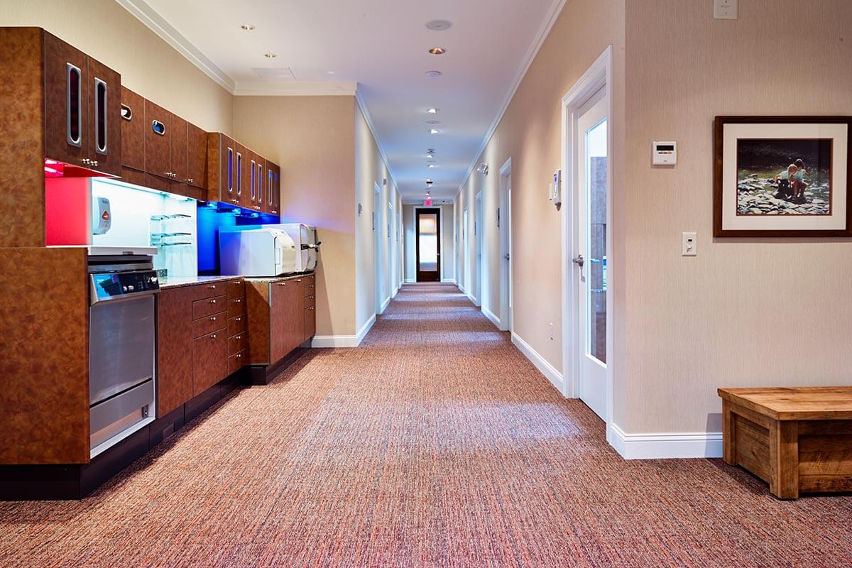 hallway of dental office with glass doors leading to exam rooms