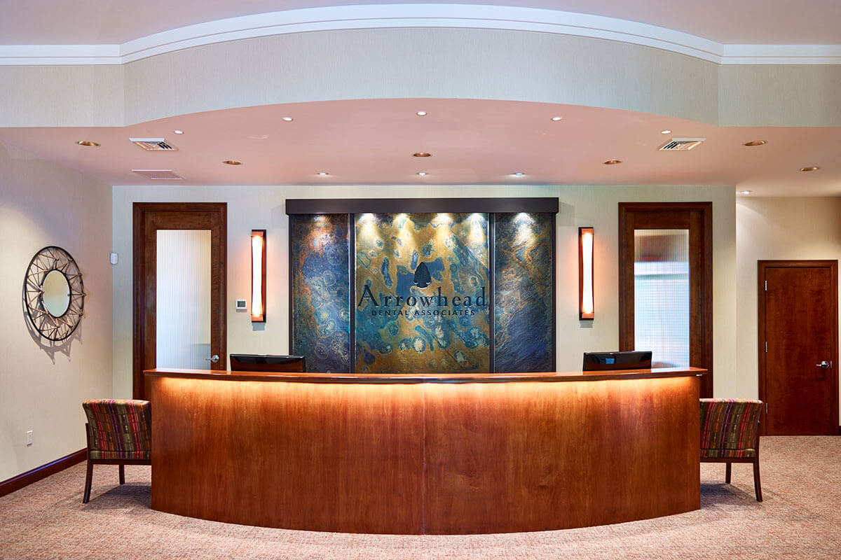 long, curved reception desk of Arrowhead Dental Associates