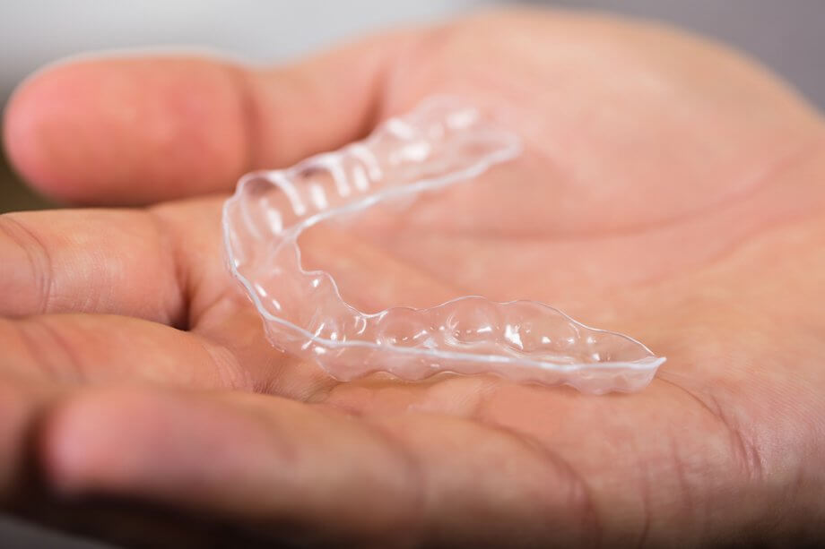 hand holding clear aligner appliance