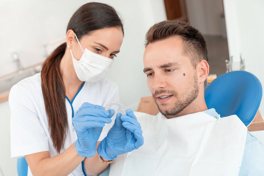 dentist showing male patient a clear aligner